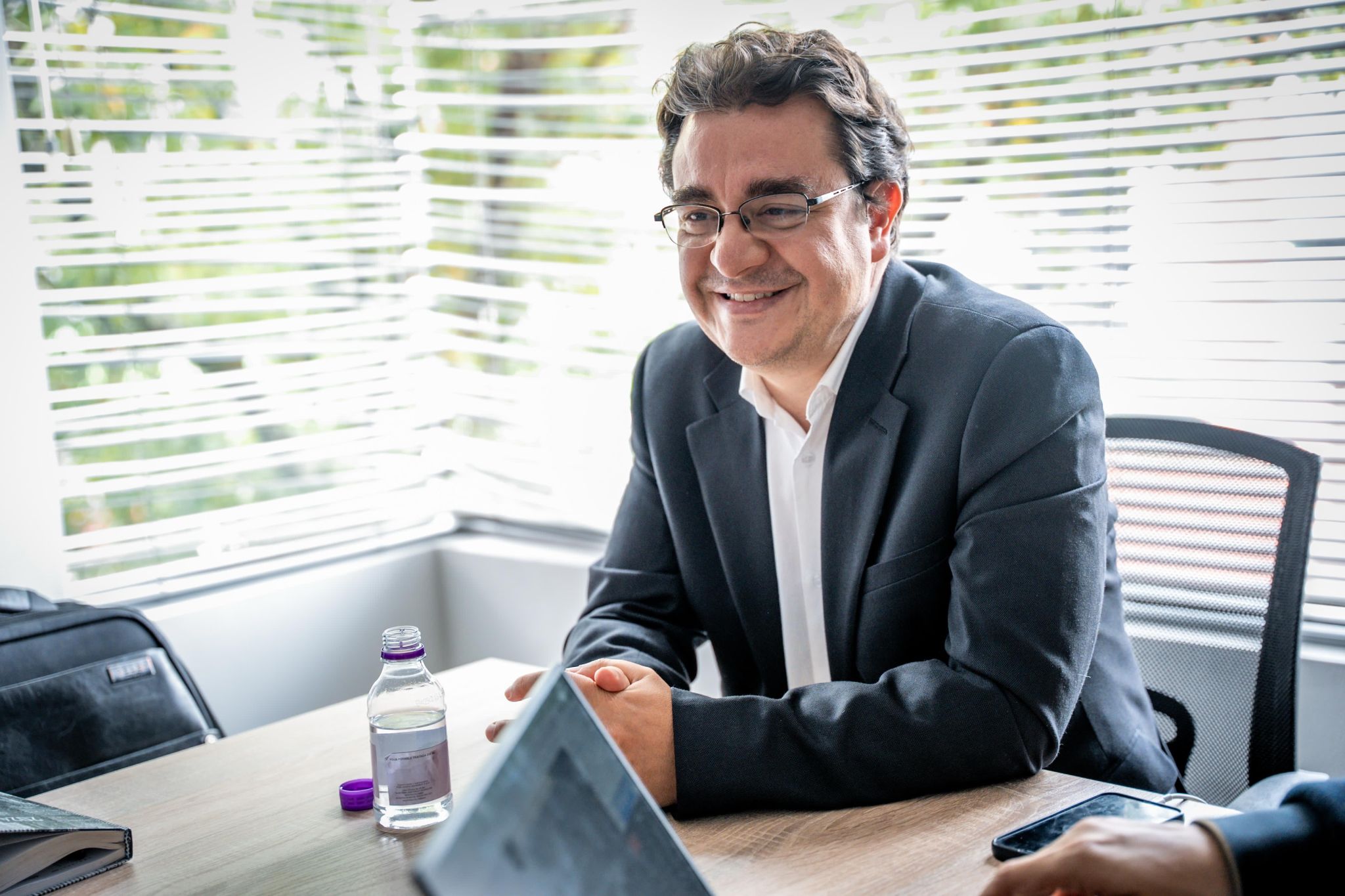 Persona sonriendo en una reunión de trabajo en oficina